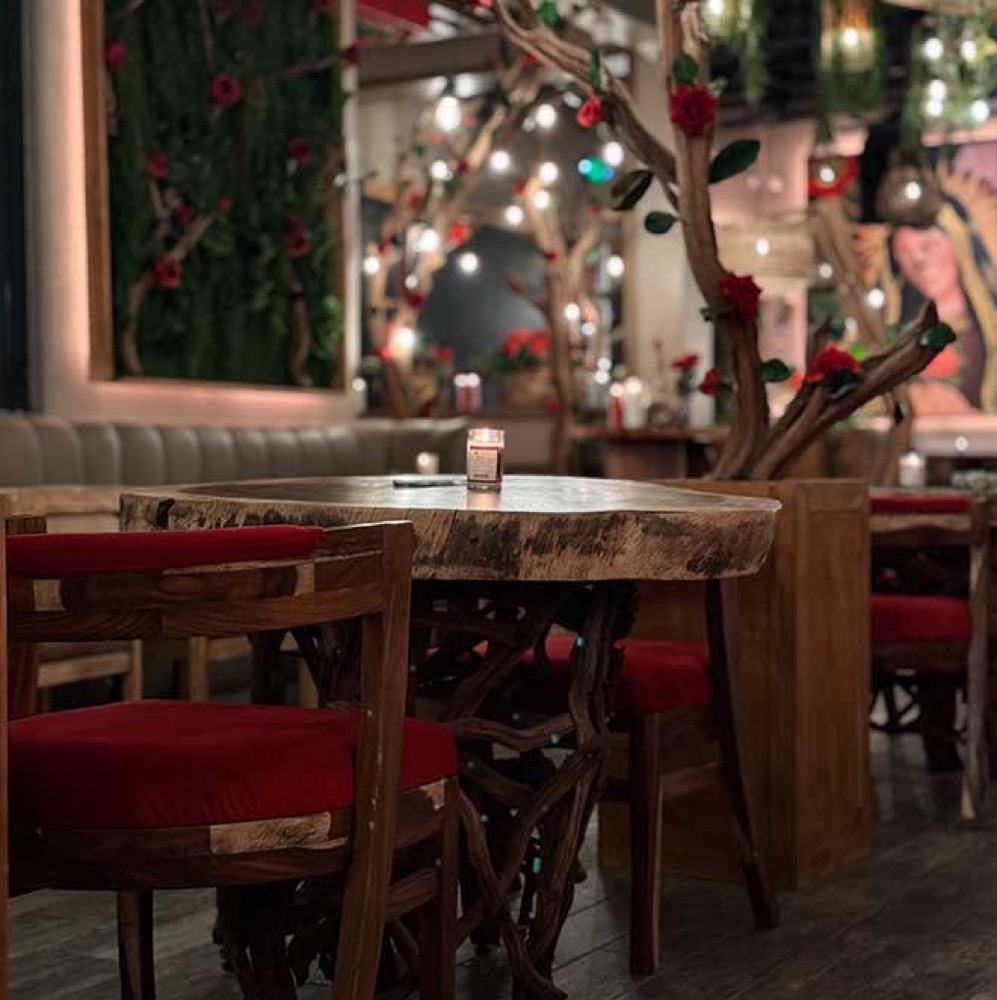 Live-edge wood tables and red velvet seating at Rosa Madera